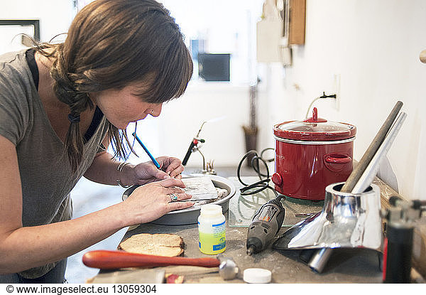 Artist making jewelry in workshop