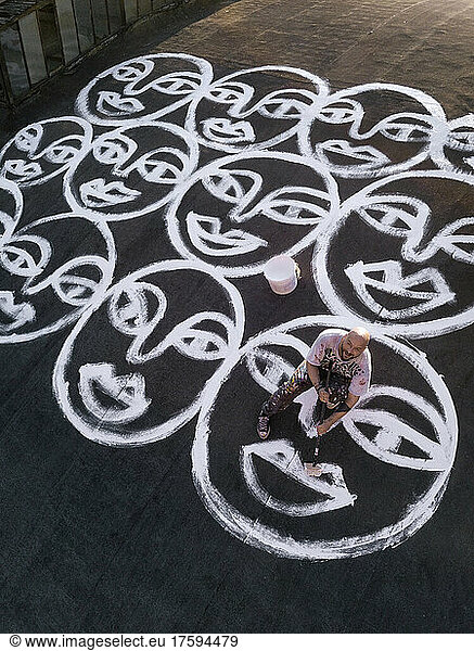 Artist painting smiley faces on roof