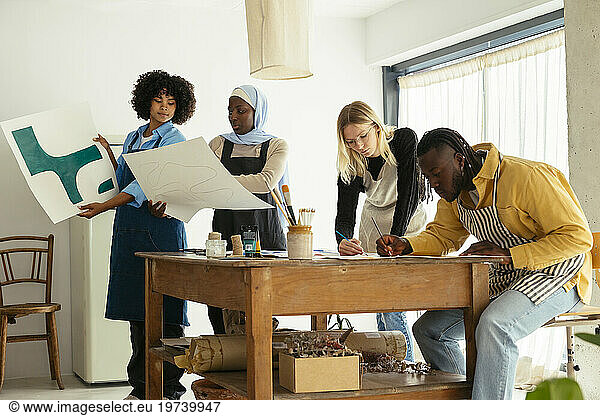 Artists working with paintings in studio