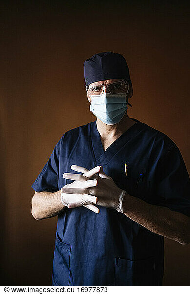 Arzt Chirurg zieht Latexhandschuhe an