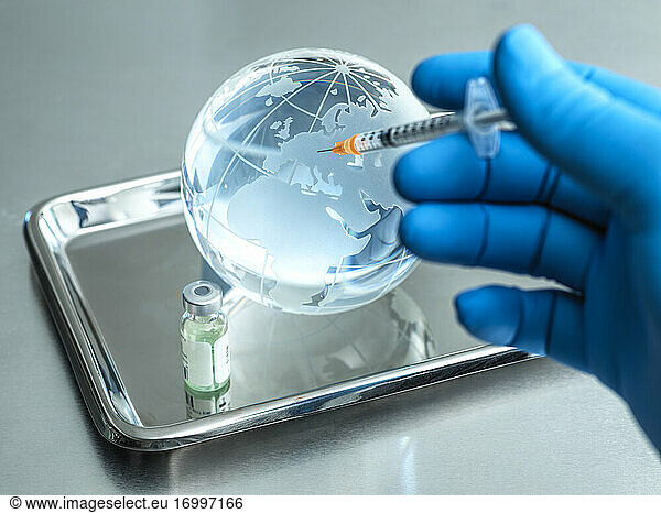 Arzt injiziert Injektion in Glaskugel durch Fläschchen auf Tisch