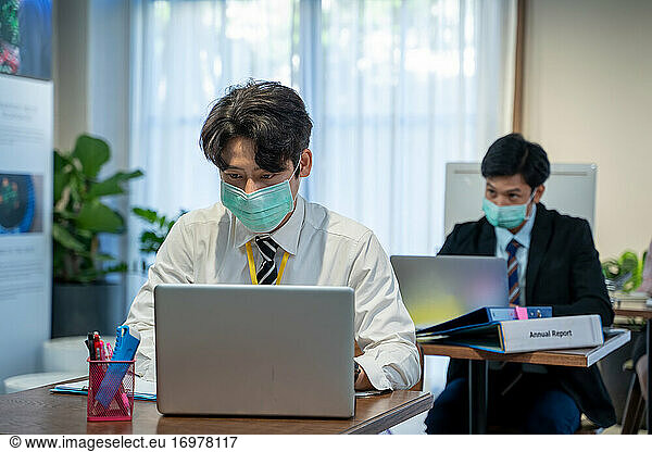Asian business people wear protective face mask due covid workin