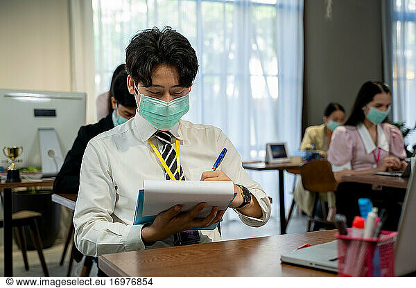 Asian business people wearing protective mask to Protect Against