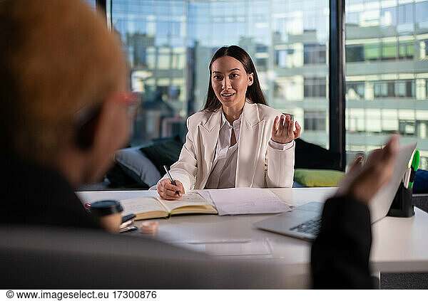 Asian businesswoman speaking with colleague
