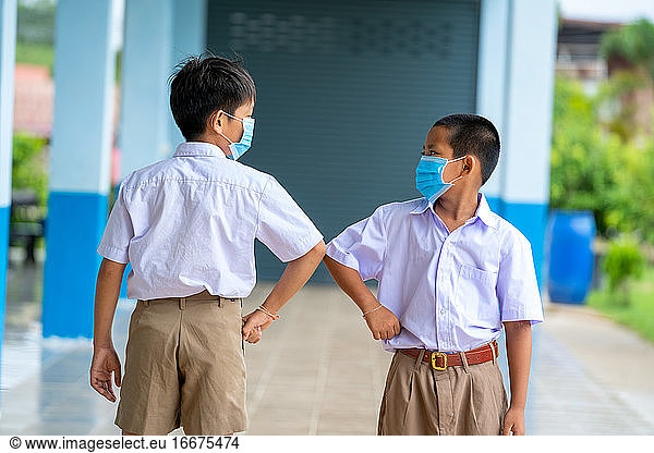 Asian children in school uniform wearing protective mask to Prot