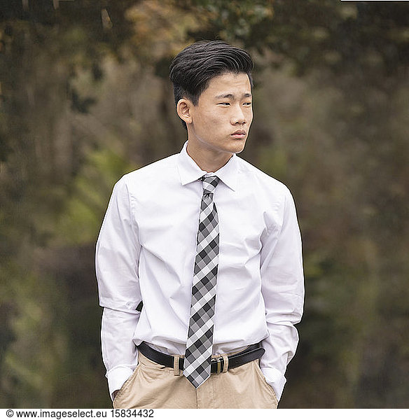 Asian Chinese teenage boy in white dress shirt  tie and khaki pants
