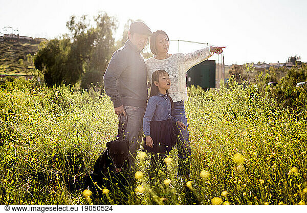 Asian Family of Three Standing in Field with Dog in San Diego