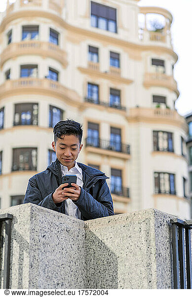 asian man sending a message from his smartphone