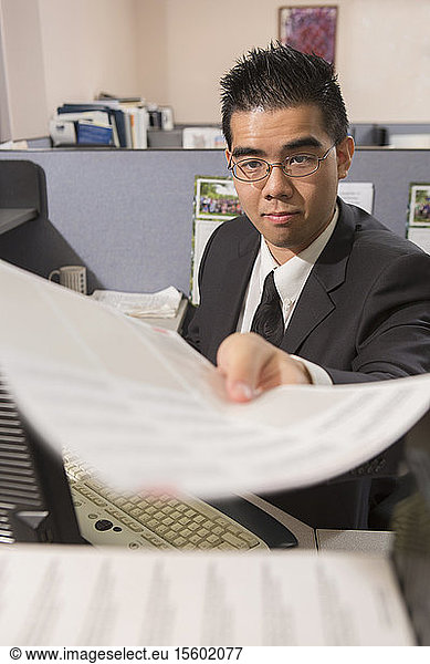Asian man with Autism doing paperwork in an office