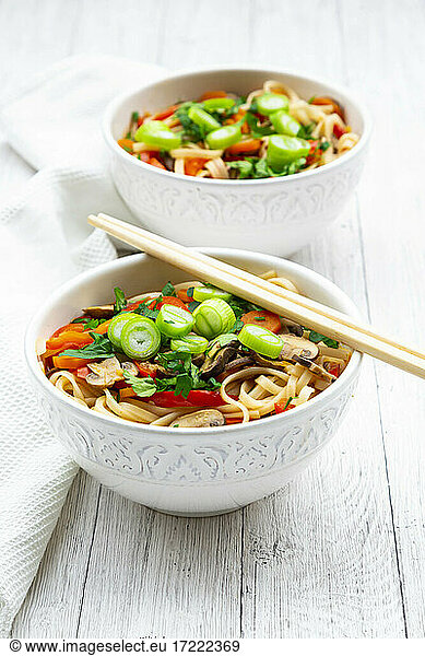Asian noodle soup with rice noodles  bell pepper  mushrooms  spring onions  coriander and carrots