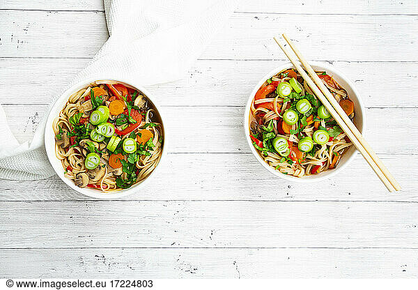 Asian noodle soup with rice noodles  bell pepper  mushrooms  spring onions  coriander and carrots