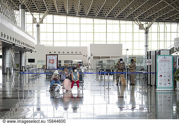 Asian passengers wearing face masks waiting at a deserted airport due to the health crisis caused by Coronavirus in Kajuraho  Madhya Pradesh  India.