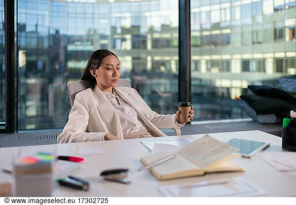 Asiatische Geschäftsfrau ruht sich im Büro aus