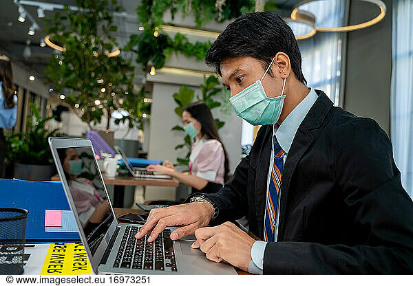Asiatische Geschäftsleute tragen Schutzmasken zum Schutz gegen