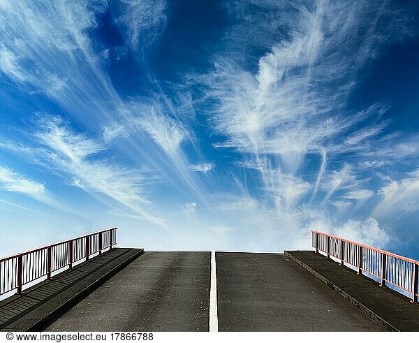 Asphalt road going into sky with clouds