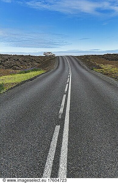 Asphalt road  volcanic landscape in summer  off-road vehicle on the horizon  Reykjanes Peninsula  Iceland  Europe