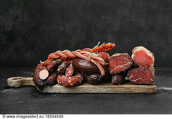 Assortment of pork sand beef ausages  ham and meat on wooden cutting board