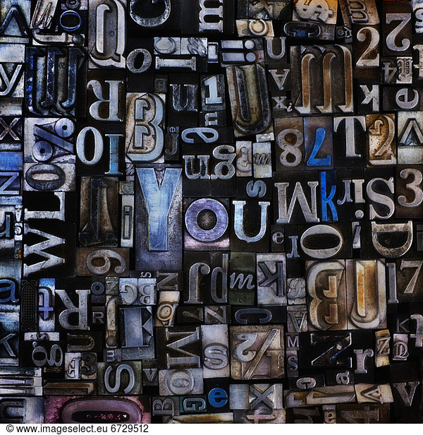 Assortment of printing blocks with word YOU in the middle of picture