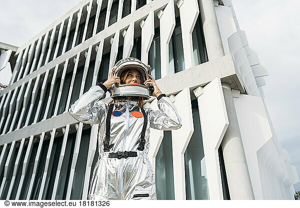 Astronaut wearing space helmet in front of building
