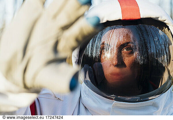 Astronautin mit Weltraumhelm  der das Gesicht vor Sonnenlicht schützt