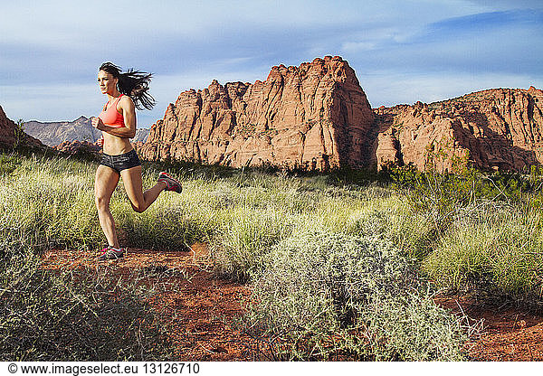 Athlet joggt auf Feld gegen Berge