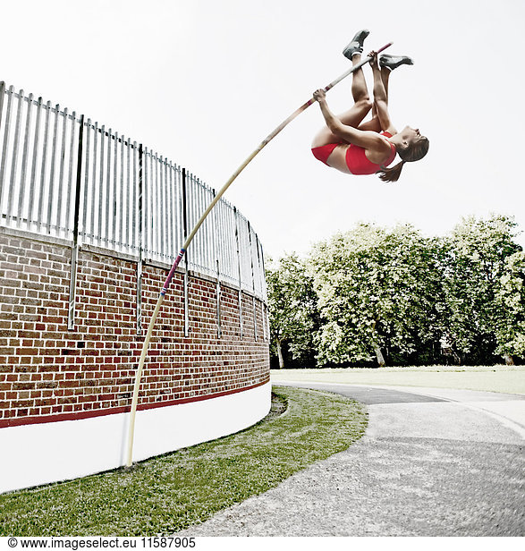Athlet springt über Ziegelmauer