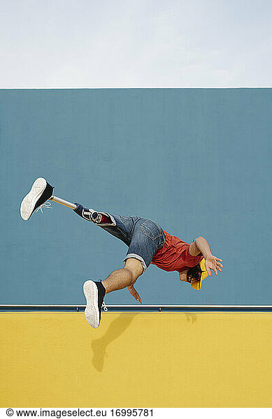 Athlet springt gegen mehrfarbige Wand