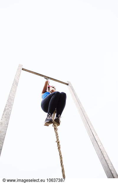 Athlete climbing rope
