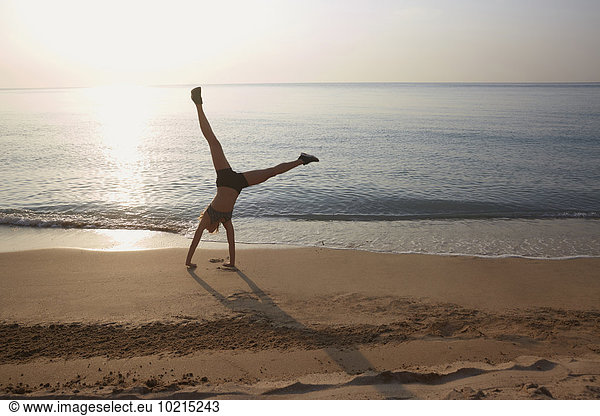 Athlete doing cartwheel on beach