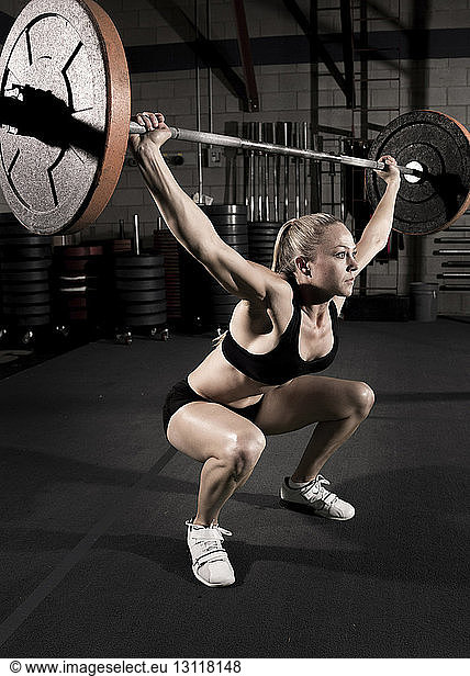 Athlete exercising with barbell at gym