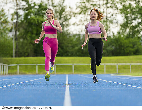 Athlete friends running on sports track
