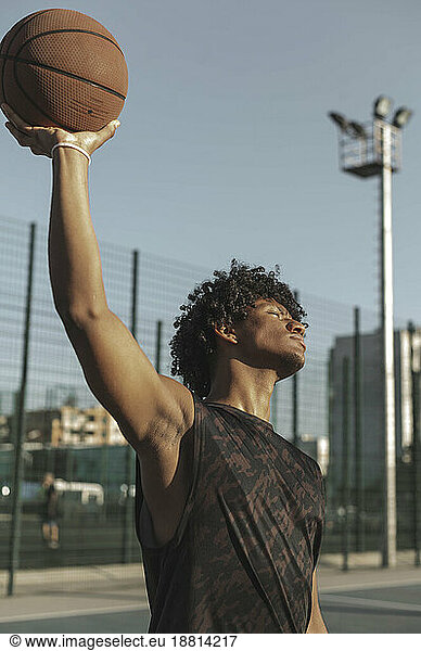 Athlete holding basketball in hand at sports court