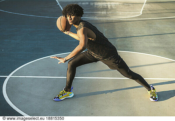 Athlete throwing basketball standing in sports court