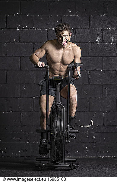 Athlete with an amputated arm doing air bike workout