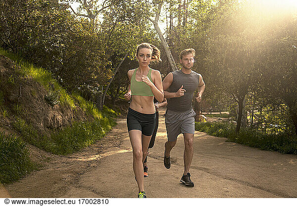 Athleten beim gemeinsamen Laufen auf dem Fußweg