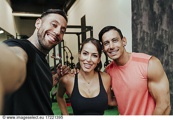 Athleten lächelnd bei der Aufnahme von Selfies im Fitnessstudio
