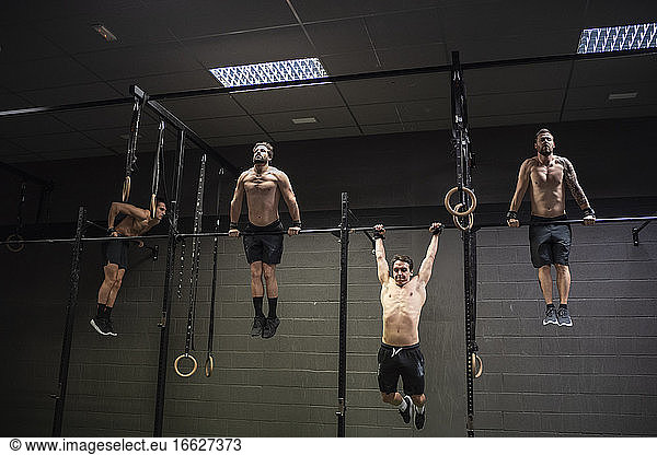 Athleten machen Klimmzüge an der Stange im Fitnessstudio