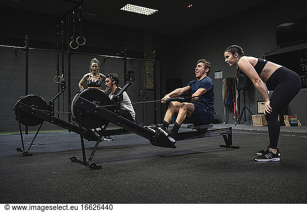 Athleten trainieren mit einem Rudergerät im Fitnessstudio