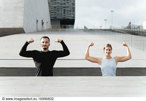 Athleten zeigen ihre Muskeln  während sie an einer Stützmauer stehen