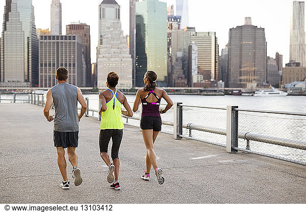 Athletes jogging on promenade by river