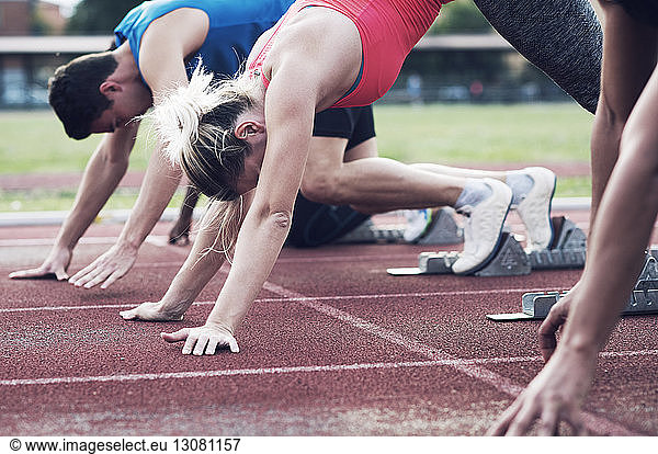 Athletes poised at starting blocks on track