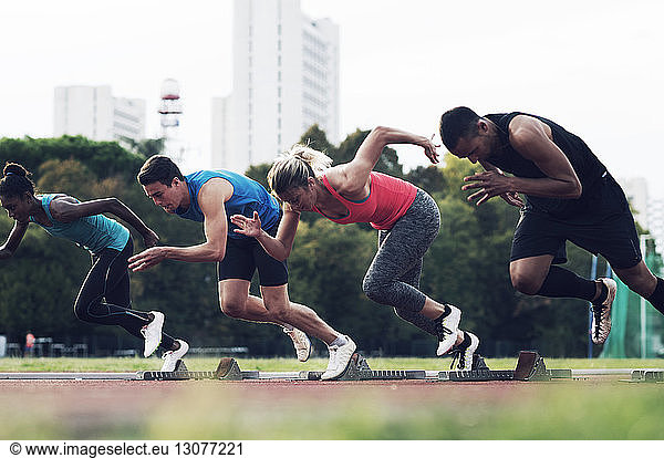 Athletes running from starting blocks on track