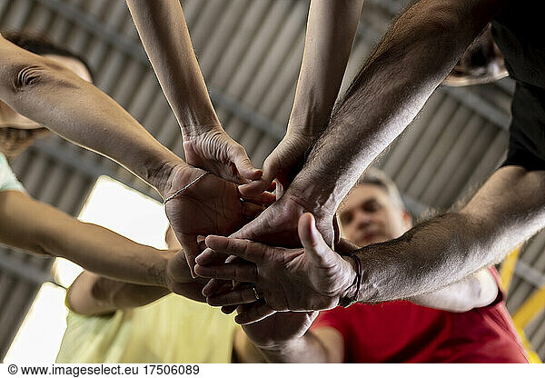 Athletes stacking hands together in gym
