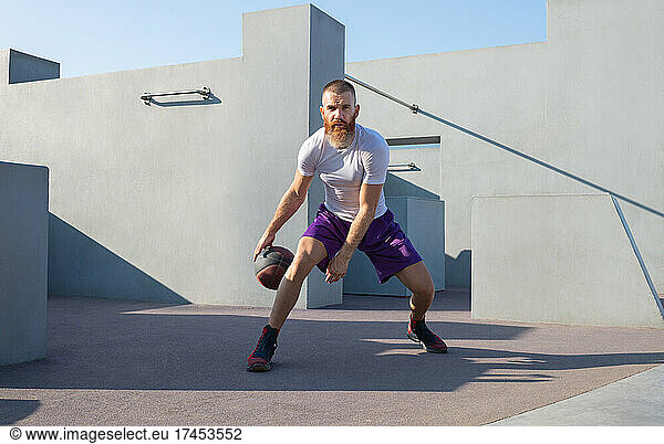 Athletic player exercising with basketball ball