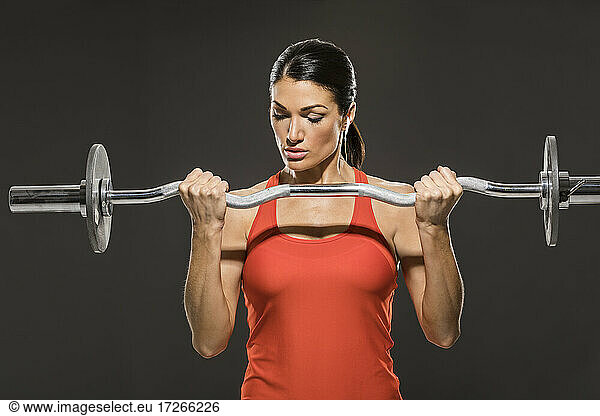 Athletic woman in red sleeveless top weight training