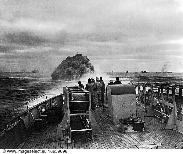 Atlantic Ocean  1943
Coast Guardsmen on the Cutter Spencer watching their depth charge explosion that blasted a Nazi U-Boat hoping to attack the convoy in the background  to the surface where it was engaged by the Coast Guard Cutter Spencer .