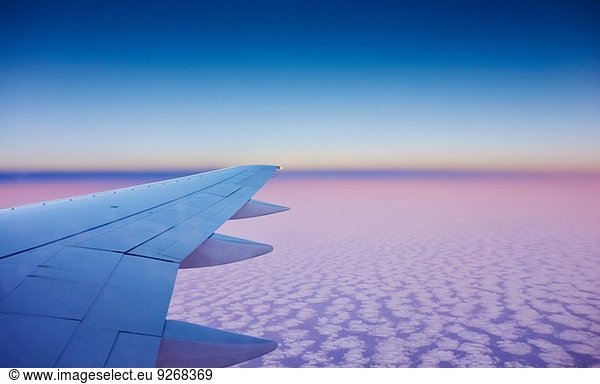 Atmosphärische Höhenansicht des Flugzeugflügels über den Wolken