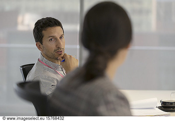 Attentive businessman listening to colleague in meeting