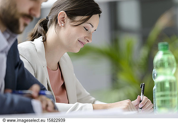 Attentive businesswoman sitting meeting  listening smiling