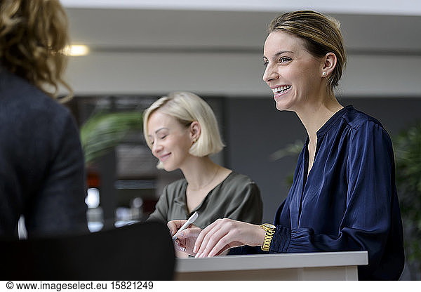 Attentive businesswomen sitting meeting  listening smiling